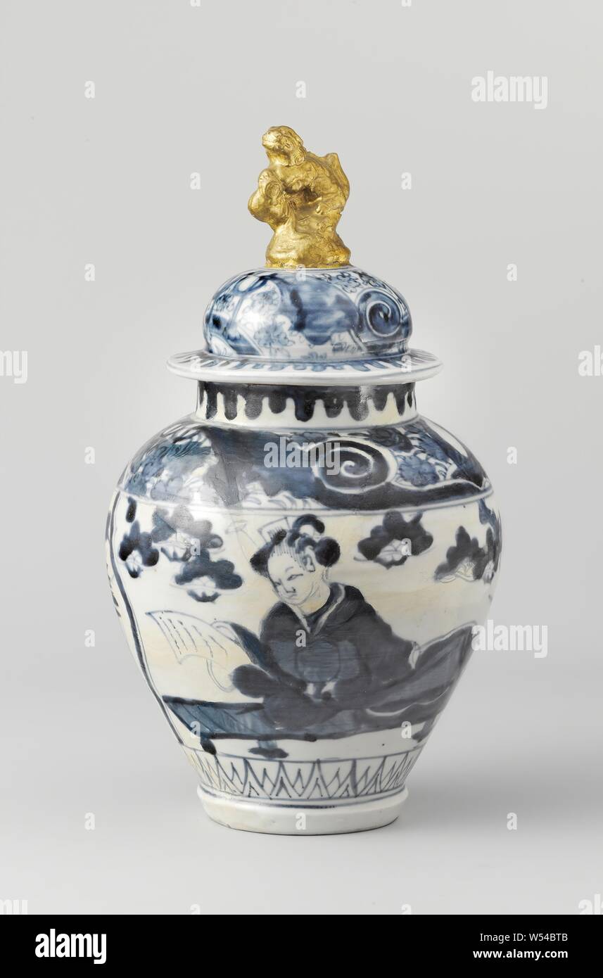 Ovoid covered jar with a lady reading a letter and final in the shape of a shishi, Lid made of egg-shaped porcelain covered pot, painted in underglaze blue and on the glaze gold. Decorated with a band of spirals and prunus flowers. Cover knob in the shape of a shishi (lion dog) on a rock, covered with gold paint. The lid button has been broken. Arita, blue and white., anonymous, Japan, c. 1650 - c. 1699, Edo-period (1600-1868), porcelain (material), glaze, cobalt (mineral), gold (metal), vitrification, h 11.5 cm × d 12.9 cm Stock Photo