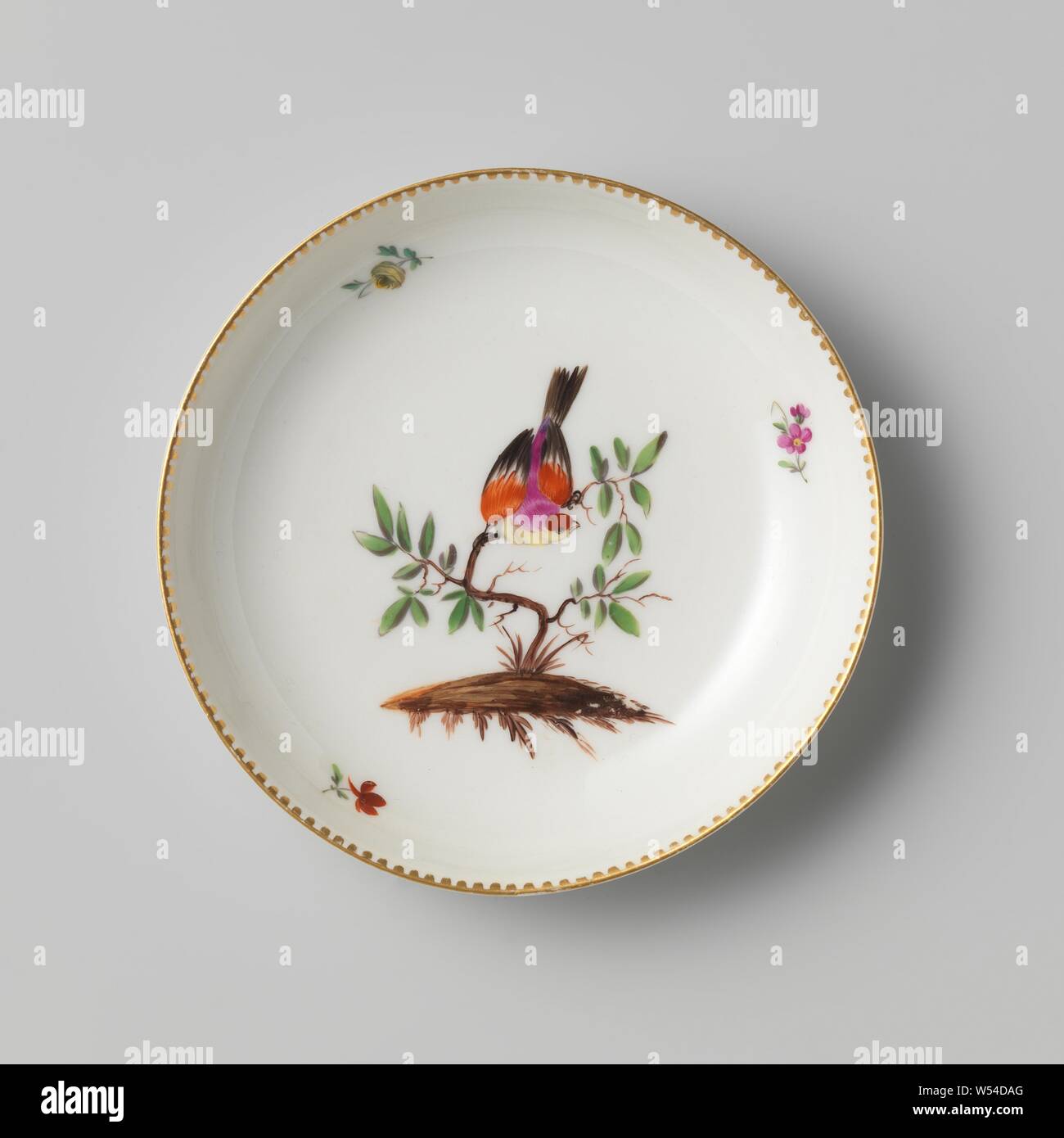 Saucer with shrub with bird and scatter flowers, Porcelain saucer. Painted with a bush with a large bird in it, and some scattered flowers. Along the edges a small decor in gold., Manufactuur Oud-Loosdrecht, 1774 - in or before 1784, porcelain (material), h 2.7 cm × d 12.6 cm Stock Photo