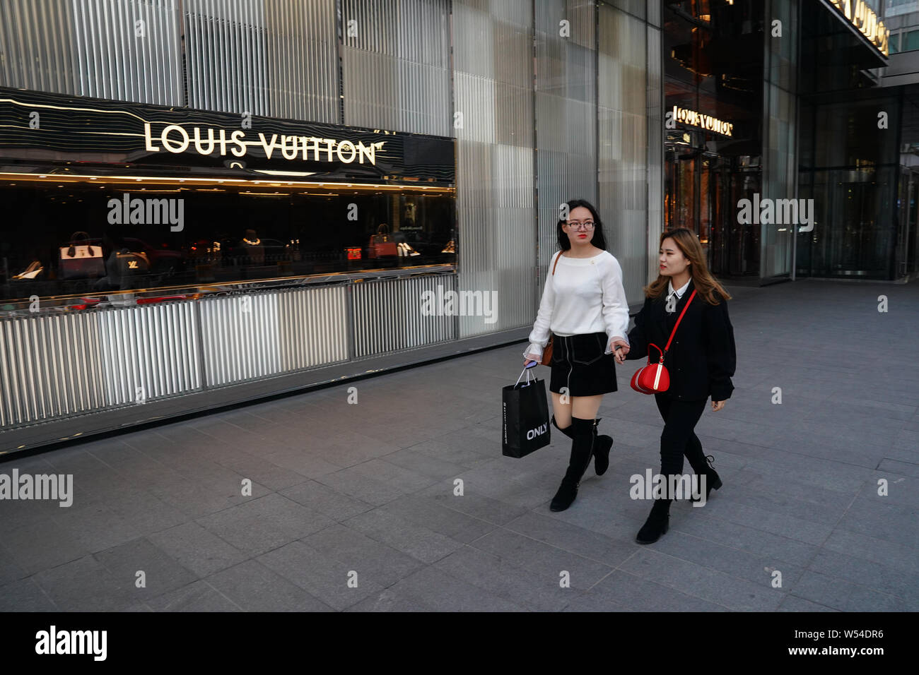 FILE--Pedestrians walk past a boutique store of Louis Vuitton (LV) in  Beijing, China, 3 November 2018. About half of Chinese consumers say  they're Stock Photo - Alamy