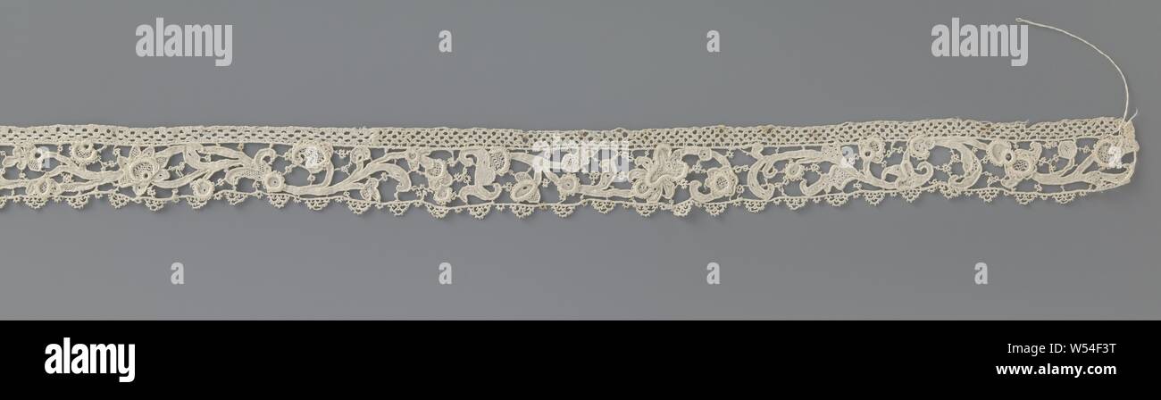 Strip of needle lace with star-shaped flower, Strip of natural-colored needle lace: Venetian rose lace. Pattern with tendrils from which flowers and leaves with different shapes and sizes, without repetitive motif. At the center is a star-shaped flower with seven petals. Irregular bars ground with picots. The top is trimmed with a bobbin lace edge. The bottom is finished with a straight picot border with curves., anonymous, unknown, c. 1700 - c. 1749, linen (material), Venetian rose point, l 70 cm × w 3 cm Stock Photo