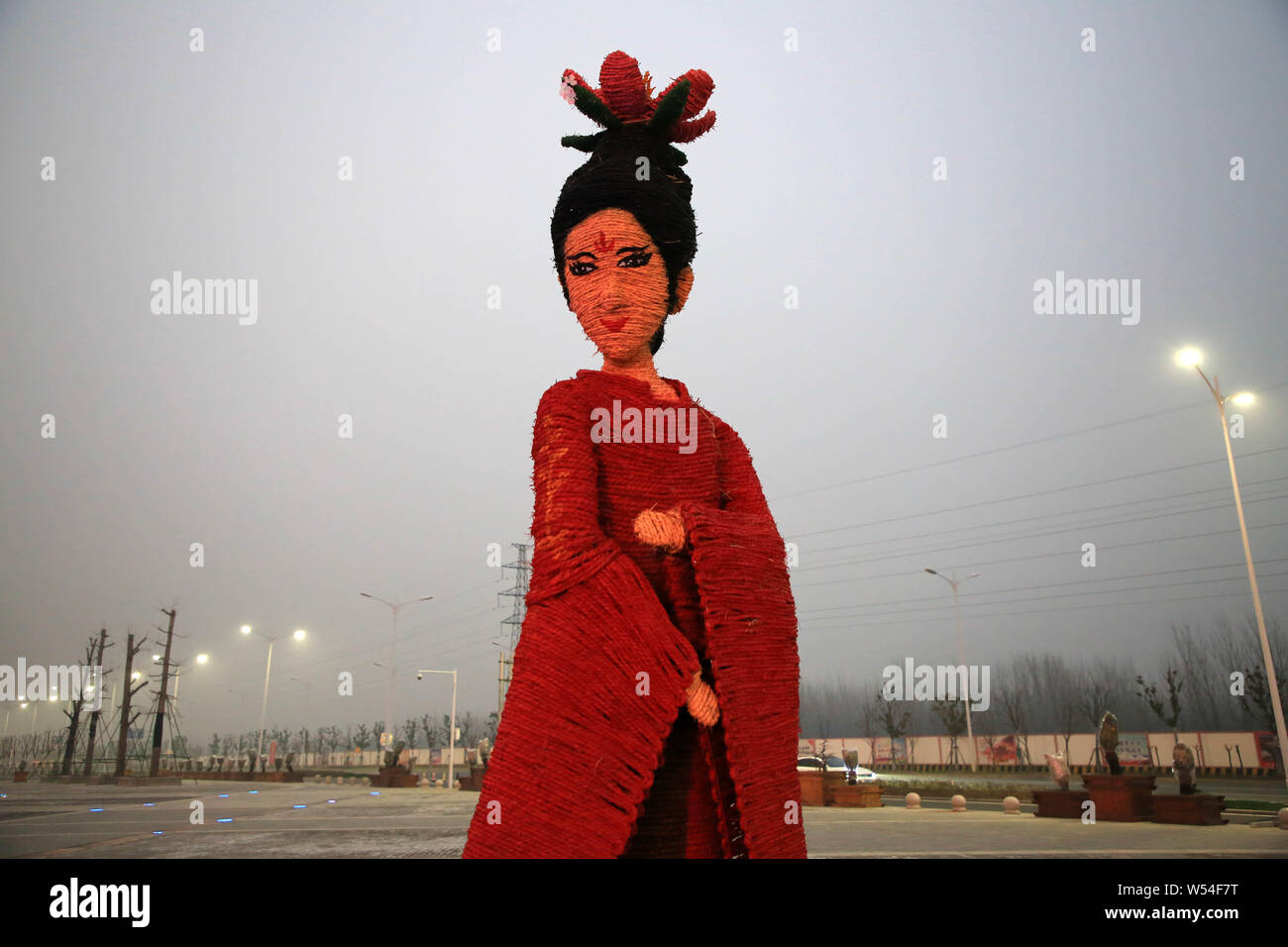 A five-meter-tall straw-made woman featuring shape of Yang Guifei stands in front of an ancient city gate to welcome tourists in Xiangyang city, centr Stock Photo