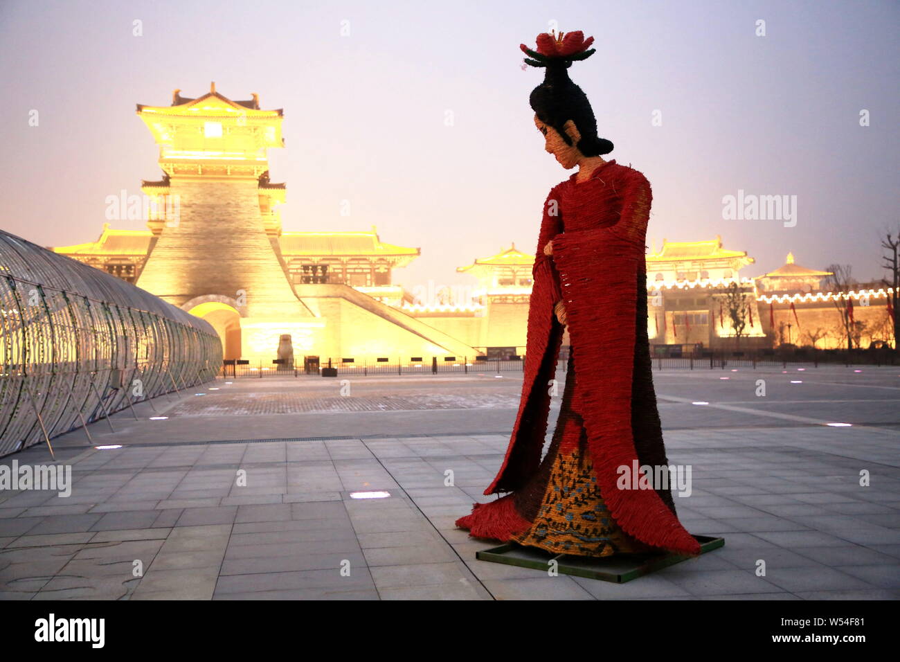 A five-meter-tall straw-made woman featuring shape of Yang Guifei stands in front of an ancient city gate to welcome tourists in Xiangyang city, centr Stock Photo