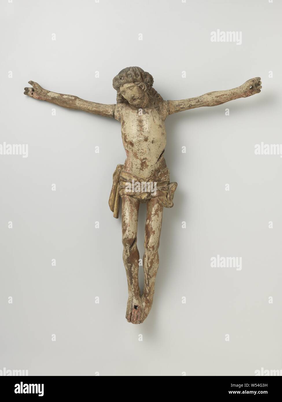 Christ crucified, Christ with a crown of thorns has the pierced right foot on the left. The arms are placed almost horizontally. The head falls slightly to the left. Two strands of hair hang down at the temples. The left end of the loincloth hangs down, the right one blows up., anonymous, Nederrijn, c. 1500, oak (wood), gilding, h 62 cm × w 60 cm × d 13 cm Stock Photo