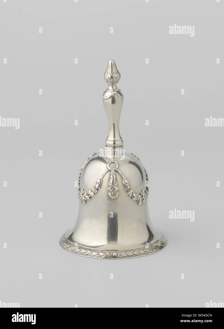 Bell bell, bell-shaped, with garlands and a wreath of laurel leaves along the edge. The bell-shaped bell is connected by a low cylindrical part to the baluster-shaped stem. This is crowned by a pear-shaped bud, separated from the stem by a constricted portion. Along the lower edge of the bell runs a slightly deepened laurel wreath, tied in three places with ribbons and in between always interrupted halfway by a ball in a circle. The bell is decorated with three equally placed flower garlands, suspended from rings on which a straight pendulum always hangs. The stem is adorned at the top Stock Photo