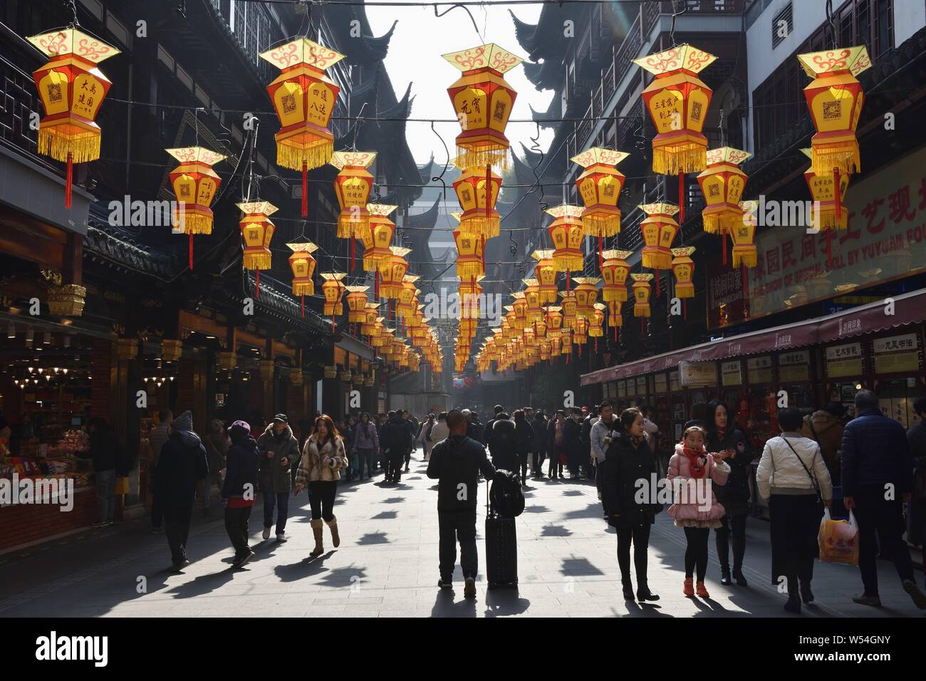 Tourists walk under traditional Chinese lanterns at Yu Garden or Yuyuan ...