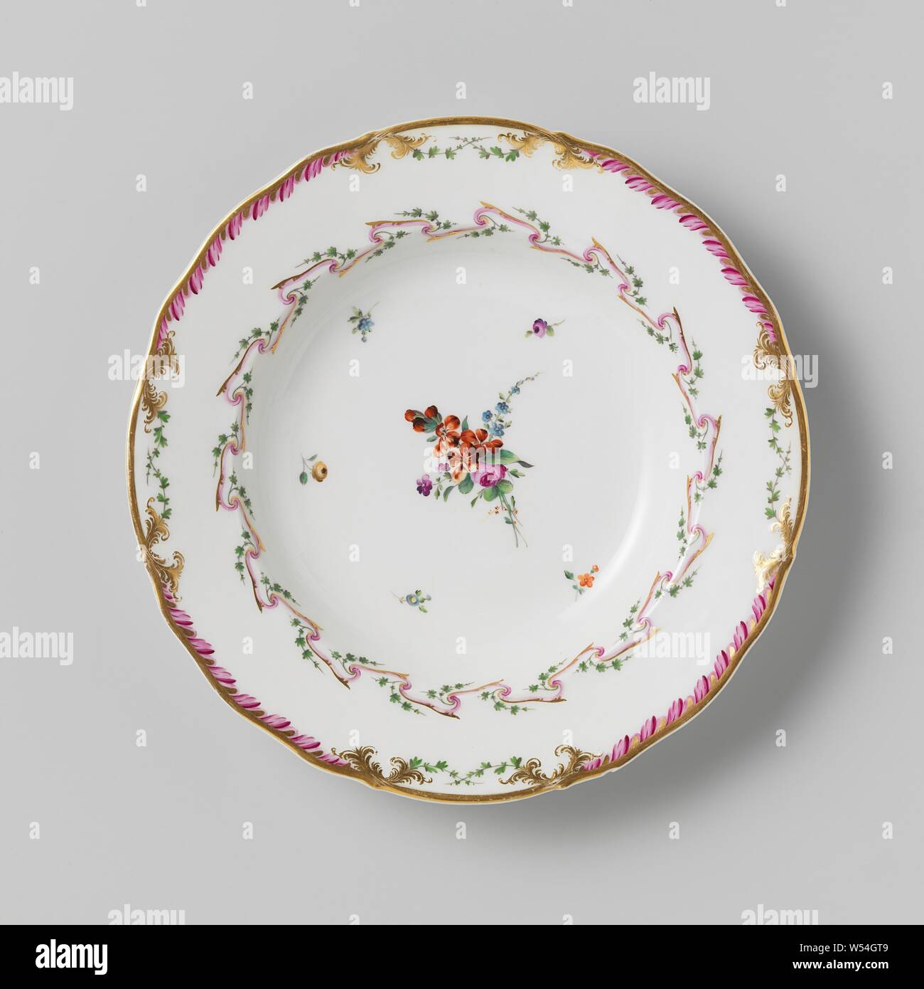 Plate, deep model, belonging to a service with a slung ribbon motif with leaves, flower bouquets and scattered flower branches, belonging to a porcelain service with slung ribbon motif in purple and gold with green leaves, flower bouquets and scattered flower branches. Borders slightly corrugated with decoration in gold with a purple leaf motif between which green crossed leaf motif. Marked: Mf. THE DIHL ET GUERHARD à PARIS. Series of eleven pieces., Dihl et Guerhard, Amsterdam, 1780 - in or before 1820, porcelain (material), h 4 cm × d 24.5 cm Stock Photo