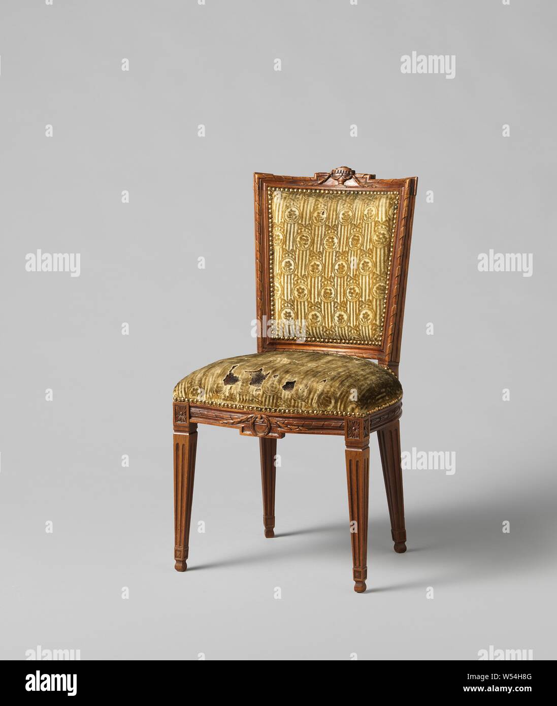 Chair of mahogany, covered with string with a continuous pattern of hanging ovals in which a flower on striped ground, covered with string with a continuous pattern of hanging oval with a flower on it a striped ground. The square legs are fluted. The front line is decorated in the middle with a laurel wreath and a pendulum. The back frame is parallelogram-shaped and concave. The upper threshold is decorated with a stabbed vase and laurel garland. The cover is attached with nails with gold-plated heads. The chair belongs to an ameublement, anonymous, Northern Netherlands, 1775 - 1800, wood Stock Photo