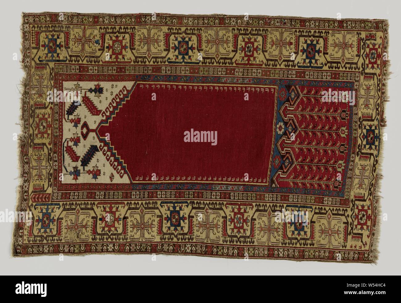 Oriental carpet, prayer rug, made of knotted wool, decorated with a red mihrab, with a blunt step gable. White spindles with saw blade. A large red field below with tulips hanging down. Around three edges., anonymous, Klein-Azie, 1700 - 1800, wool, h 175 cm × w 116 cm Stock Photo