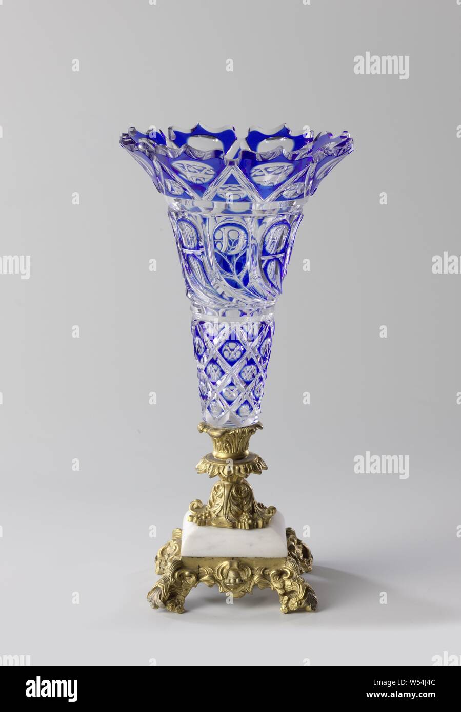 Vase with cobalt blue Überfang with cut decoration, Square, gilt bronze  base and stem in neo-Renaissance style with gray-veined marble spacer.  Trumpet-shaped chalice of clear colorless glass with a cobalt blue Überfang,
