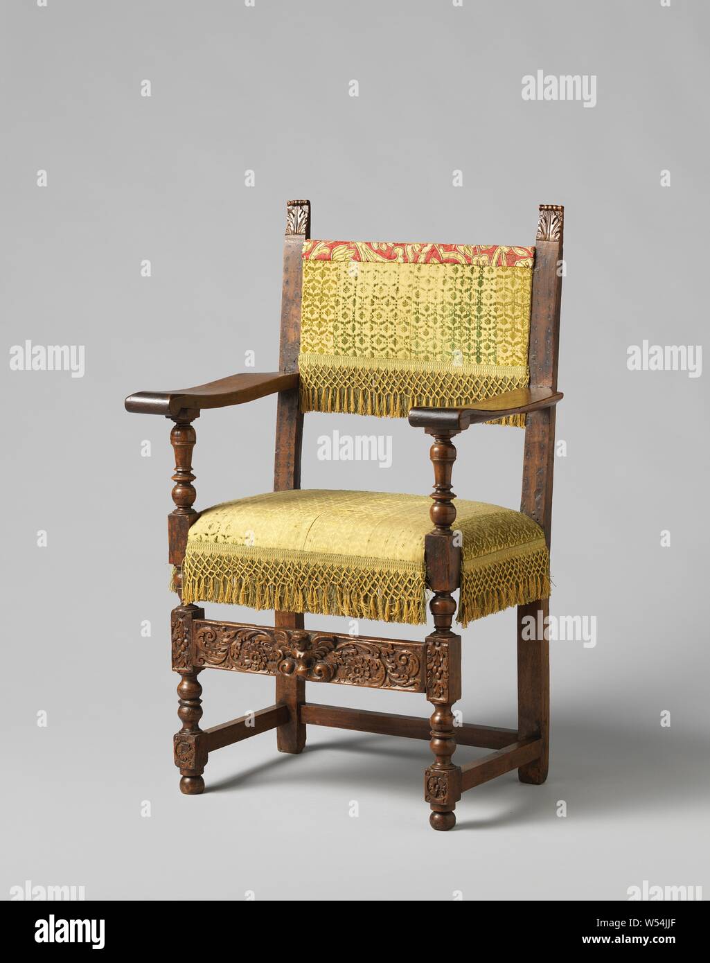 Armchair made of walnut, belonging to an furniture of four armchairs. The front legs and arm struts show house and articulation. The houses with leaf motifs are connected by a flat front line with stung leaf vines, between which a winged female figure whose abdomen changes into committed volutes. The wide, slightly hollowed flat armrests end in closed leaf forms. The back styles end in inserted leaf forms. The original damask upholstery is covered with antique fabric from a chasuble., anonymous, Spain (possibly), 1585 - 1600, wood (plant material), walnut (hardwood), textile materials, damask Stock Photo