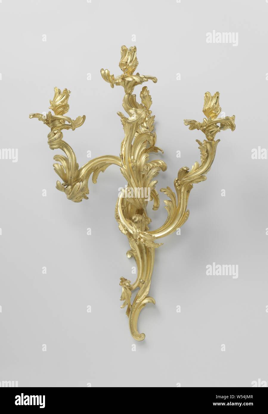 Wall arm of gilt bronze with three arms made of asymmetrical C and S-volutes, Wall arm of gilt bronze, with three arms. The trunk and arms are constructed from asymmetrical S and C-shaped leaf motifs, as well as the fat traps and candle holders. The old inventory number 14 is affixed to the wall arms., anonymous, Paris, c. 1750 - c. 1760, bronze (metal), gilding, h 80.3 cm × w 53.0 cm × d 32.3 cm Stock Photo