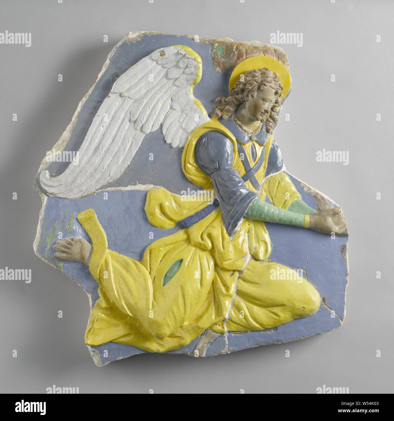 Floating angel, The angel holds an indefinable object in front of her (a fragment of). He has raised the left leg with the knee forward and the other with his foot swinging backwards. The upper part of the other wing is visible behind the nimbus. The angel wears over an undergarment, of which only the sleeves and part of the skirt can be seen through a split in the upper garment (according to the colors), a second garment with half sleeves and a collar. That is what the sleeveless outer garment is about, which is looped around the waist and hips. Stock Photo