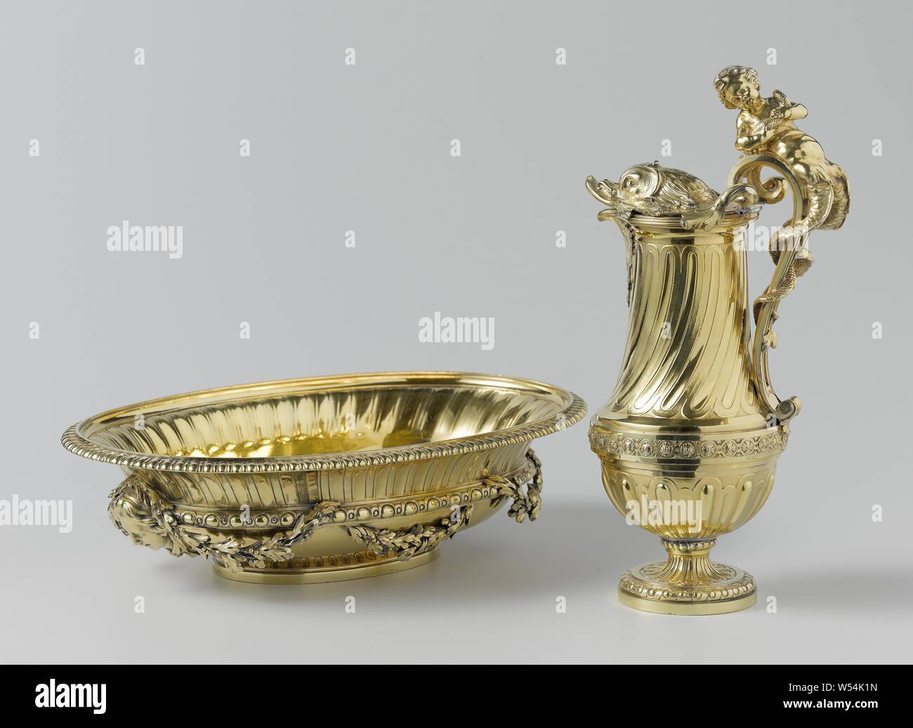 Ewer and basin, water jug, water jug of gilt silver. The jug rests on an ascending foot, has a convex underside with beamed godrons and, above a profile with rosettes, a high concave neck on which the godrons are twisted. The lid is shaped like the head of a dolphin. A crowning sea putto winds its double tail around the high rising ear, dolphin, ornament, Thomas Chancellier, Paris, 1765, silver (metal), gilding (material), gilding, h 35.0 cm × w 36.5 cm × d 24.5 cm w 15.8 cm × d 10.5 cm w 1792 Stock Photo