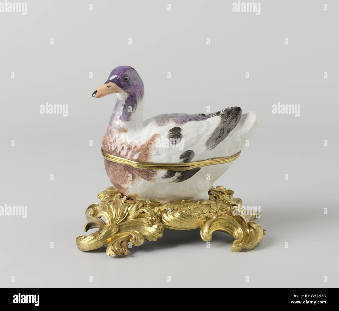 Box in the shape of a duck, Box of painted porcelain, belly of the duck, with gold-colored edge. The duck is partly painted in blue, green, brown-gray and black. The box is unnoticed., Meissener Porzellan Manufaktur, Meissen, c. 1740 - c. 1748 and/or c. 1750, porcelain (material), bronze (metal), gilding, h 5 cm × w 9 cm × d 14 cm Stock Photo