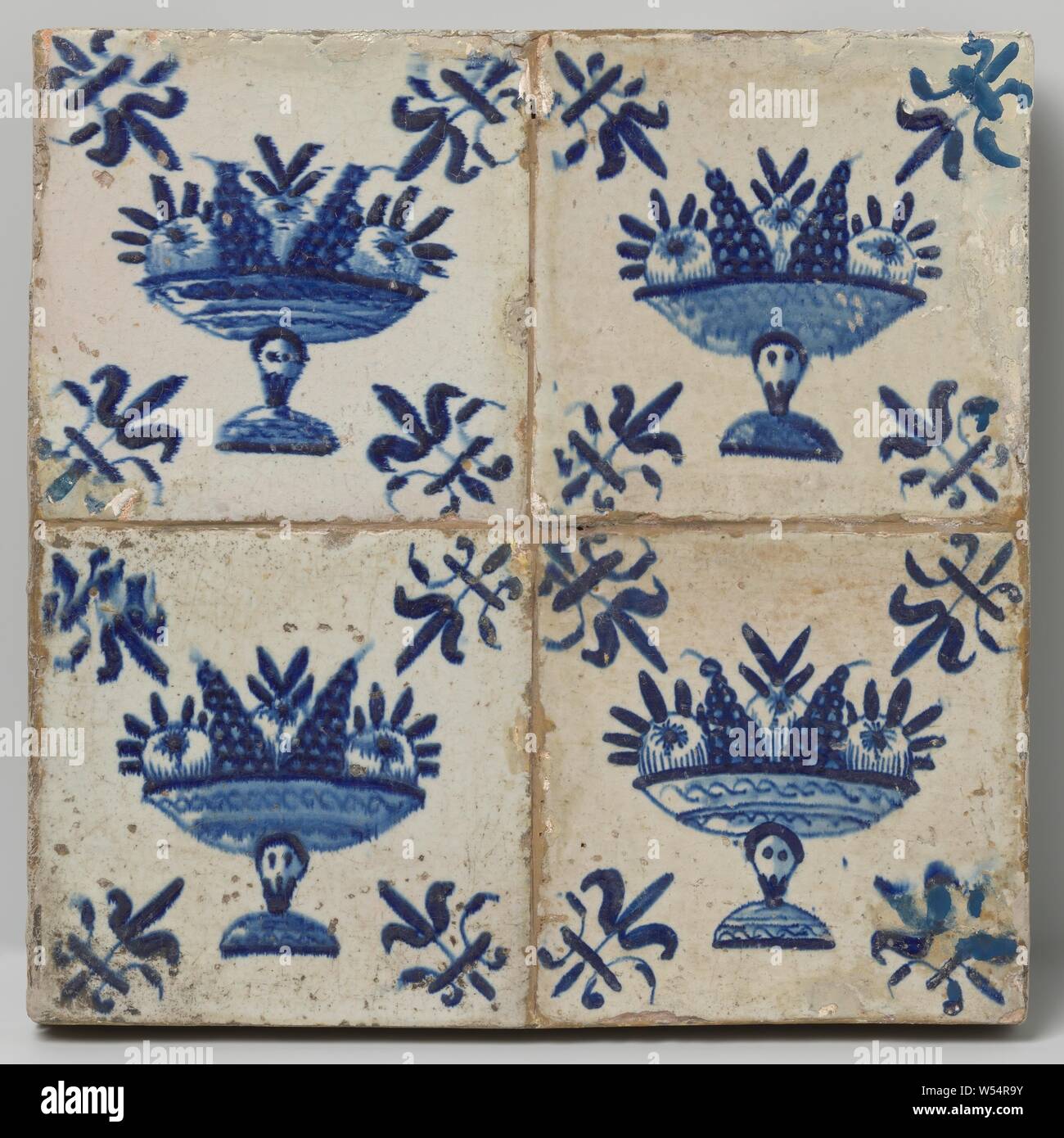 Field of four tiles with fruit bowls, Field of four tiles (2 x 2) each with a blue painted fruit bowl. In the corners, a lily., anonymous, Netherlands, c. 1640 - c. 1660, earthenware, tin glaze, h 26.5 cm × w 26.5 cm × t 3 cm Stock Photo