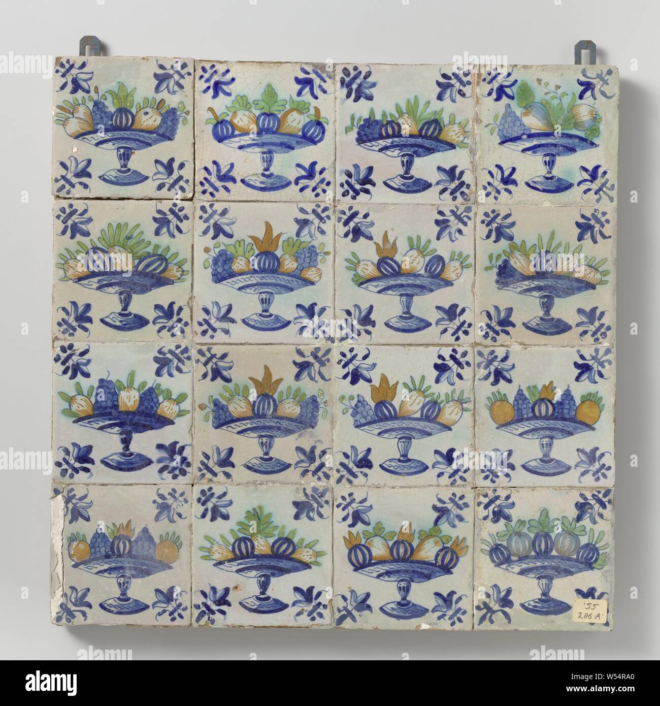 Field of sixteen tiles with fruit bowls, Field of sixteen tiles (4 x 4) each with a multicolored (blue, green, yellow and orange) fruit bowl on foot with a lily in the corners., anonymous, Netherlands, c. 1640 - c. 1660, earthenware, tin glaze, h 53 cm × w 53 cm × d 3 cm Stock Photo