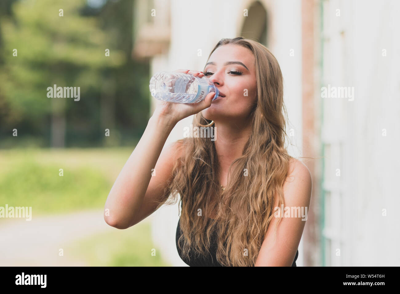 young girl drinking from water bottle Stock Photo