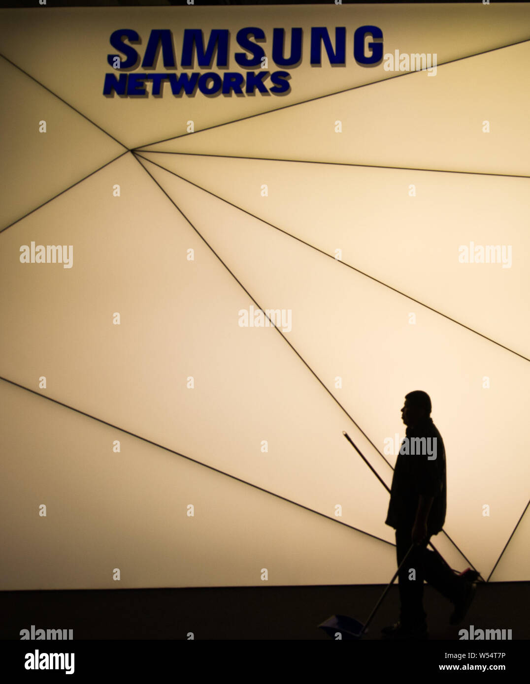 A cleaning worker walks past the stand of Samsung Networks during the Mobile World Congress 2019 (MWC19) in Barcelona, Spain, 25 February 2019. Stock Photo