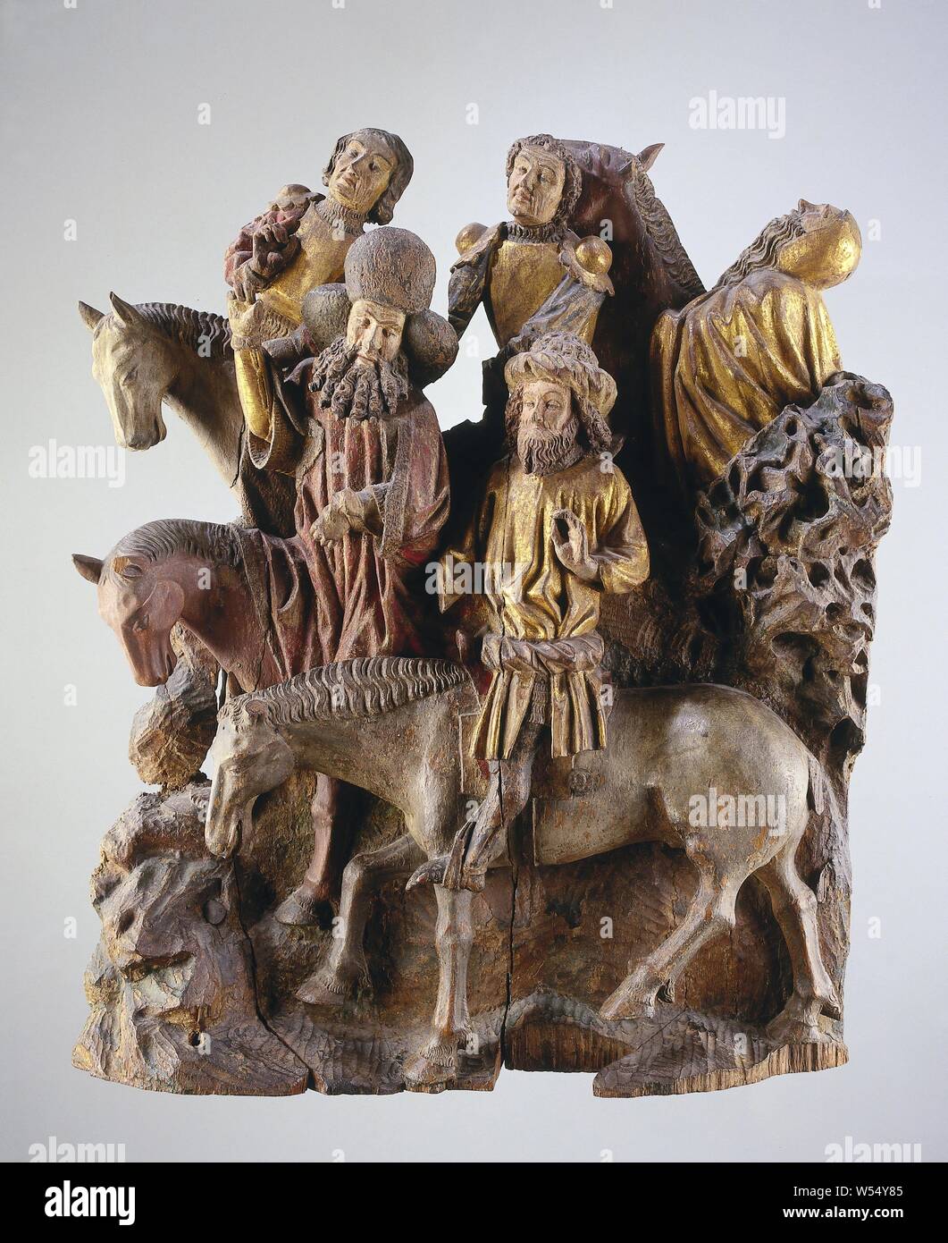 Two groups of horsemen from a Crucifixion scene Group of Horsemen from a Calvary Scene, from a Passion Altar, In the ascending landscape with scrub on the right and a rock formation on the left five horsemen to the left. The front one with straight legs in the stirrups holds the left hand in front of the chest, with the judge, who is missing, he kept the horse under control. He seems to be listening to the rider riding next to him, probably the chief, who points up (to Christ) and holds the horse by the left with the bridle. Both riders wear a beard. Behind them two soldiers, the left one Stock Photo