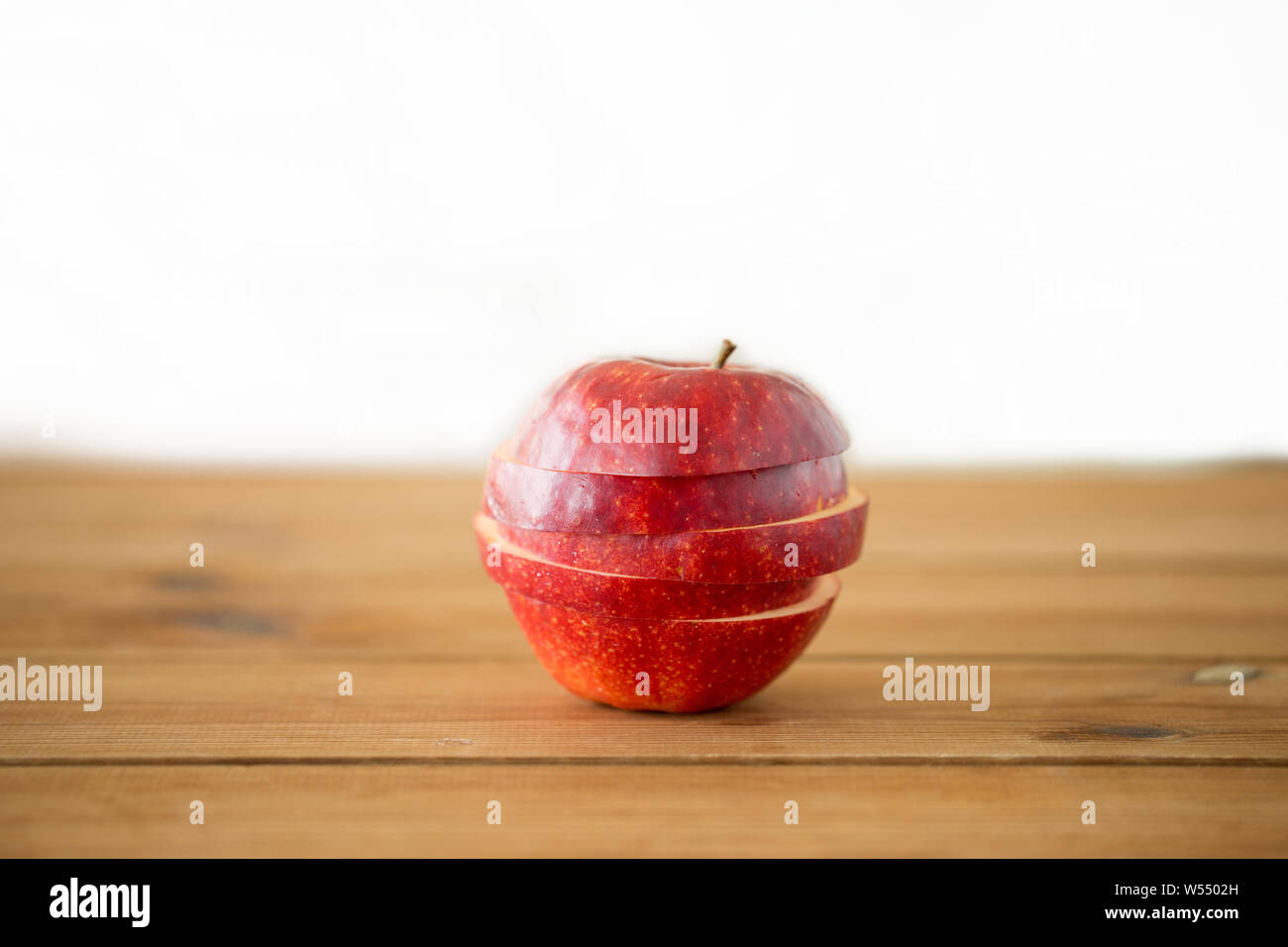 sliced red apple on wooden table Stock Photo