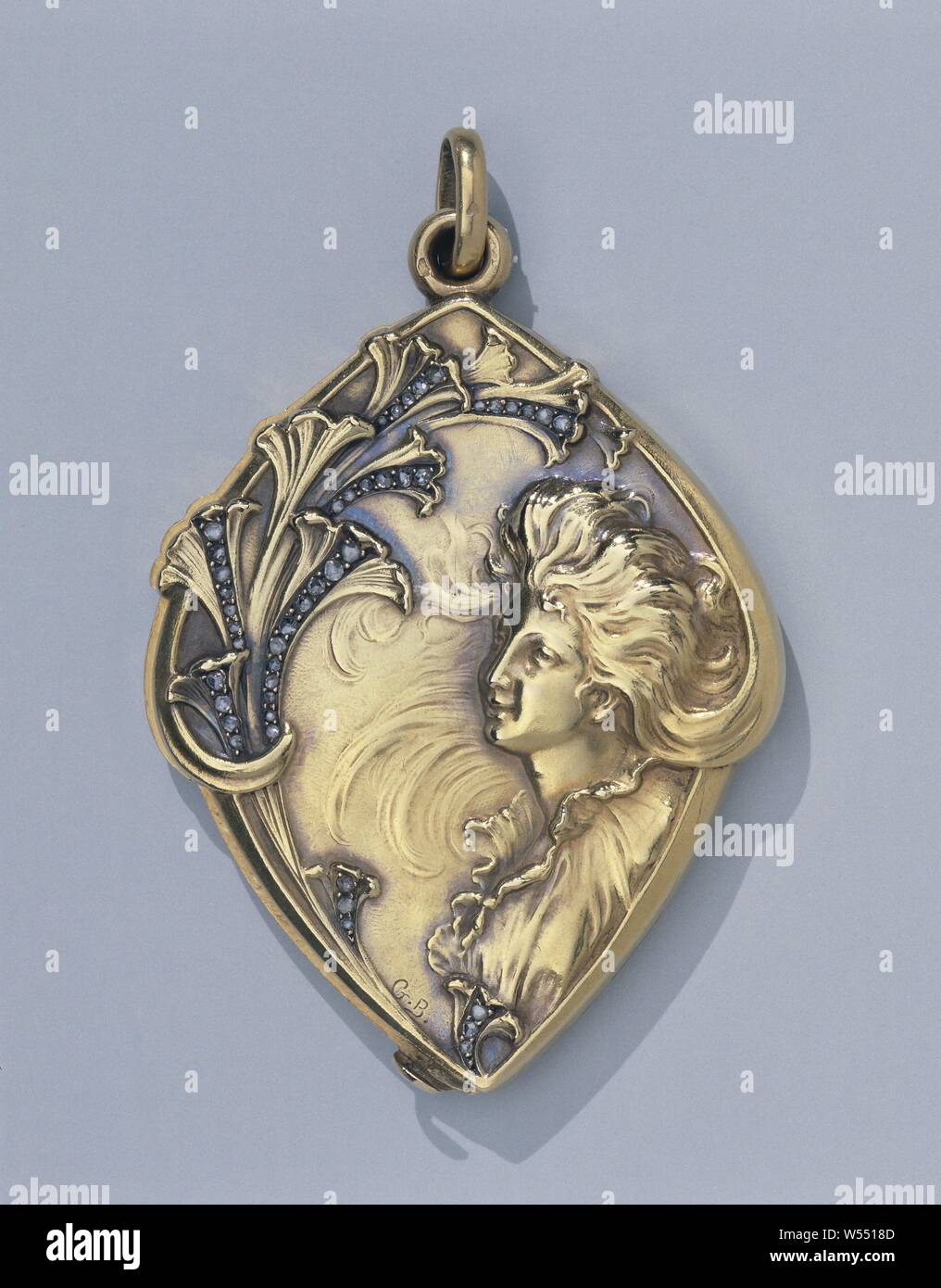 Pendant with a woman's portrait with wavy hair and stylized flowers, Pendant made of gold, diamonds and mirror. In Art Nouveau style with a woman's portrait with wavy hair and stylized flowers., anonymous, Paris, c. 1900, gold (metal), diamond (mineral), looking glasses, h 6.6 cm × w 4.2 cm × d 0.7 cm Stock Photo