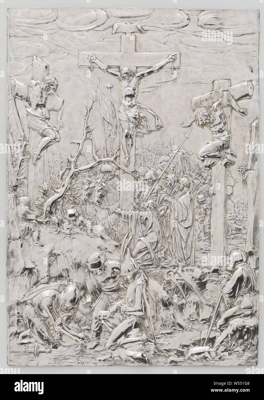 The Crucifixion, Crucifixion, A silver driven plaque with a depiction of the Crucifixion. Christ on the cross in the middle. At the foot of the cross is Mary Magdalene kneeling, on the right are Mary and John, crucified Christ, with particular persons under the cross - DD - the three crosses, soldiers throwing dice for Christ's seamless garment, Christ's death on the cross, Arent van Bolten (attributed to), c. 1610, silver (metal), h 28.9 cm × w 20.4 cm × t 0.9 cm × w 294 Stock Photo