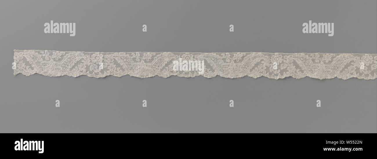 Strip of bobbin lace with carnation in a U-shaped reserve, Natural strip of bobbin lace: Mechelen lace. The repeating pattern consists of two compositions, one with a carnation hanging from a U-shaped reserve and the other with an arch formed by two flower branches with one rosette flower in the top. The motifs are connected by a fine mesh ground, the Mechelen ground. The motifs are made in linen with cutouts, and are provided with thicker and shiny contour threads. A decorative ground with snowflakes combined with larger round motifs has been applied in the u-shaped reserves. The scalloped Stock Photo