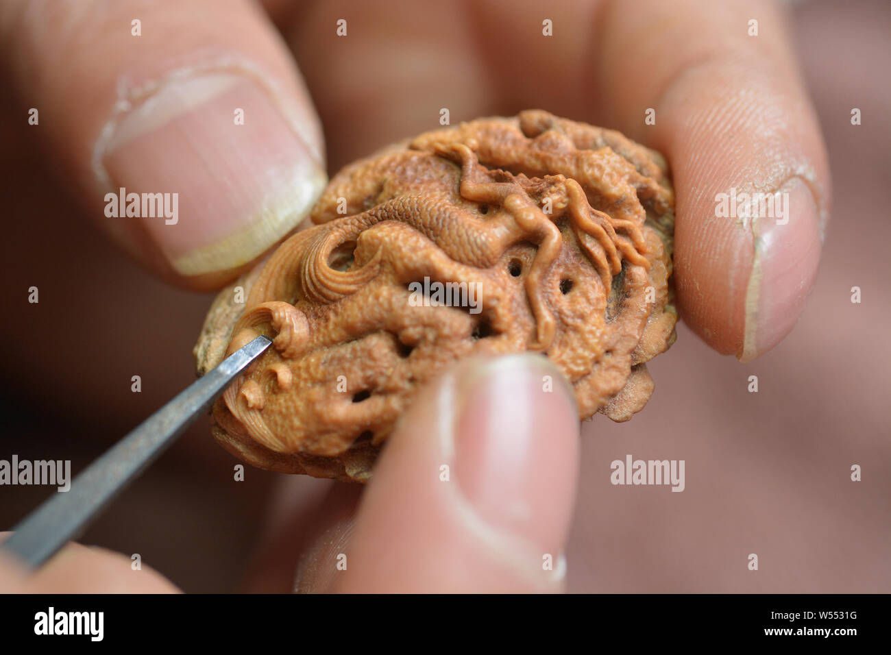 Chinese Artist Li Yanjun Works On A Micro Sculpture On A Peach Pit At His Home In Mayuzi Village Zhailihe Town Juxian County Rizhao City East Chin Stock Photo Alamy