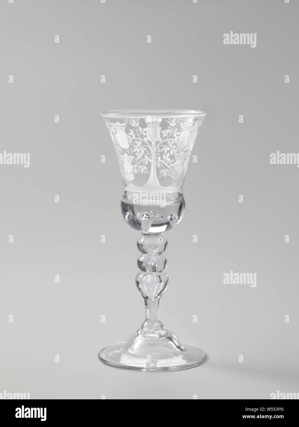 Wine glass with a tree with the seven arms of the Republic of the Seven United Netherlands Cup with the arms of the Seven Provinces, Bell shaped arched foot. Baluster stem with two knots and an elongated air bubble. Bell-shaped chalice with massive, rounded base with air bubbles. On the chalice the weapons of the Seven Provinces, coat of arms (as symbol of the state, etc.), Seven provinces, anonymous, c. 1725 - c. 1750, glass, glassblowing, h 23.3 cm × d 10.4 cm Stock Photo