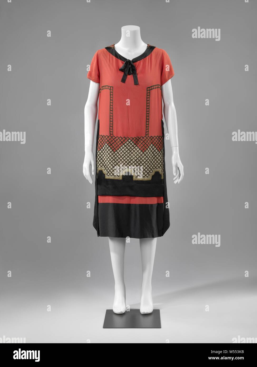 Evening dress of red, black and white silk with cord embroidery, black and white silk with cord embroidery. Geometric art nouveau. Three-quarters long, straight model without dummy seams. Long round neck. Short sleeves. On the front a loose hanging smooth strip of white over black with a tilted middle edge, accented with gold and silver cord., anonymous, Paris (possibly), 1920, silk, satin, l 107 cm Stock Photo