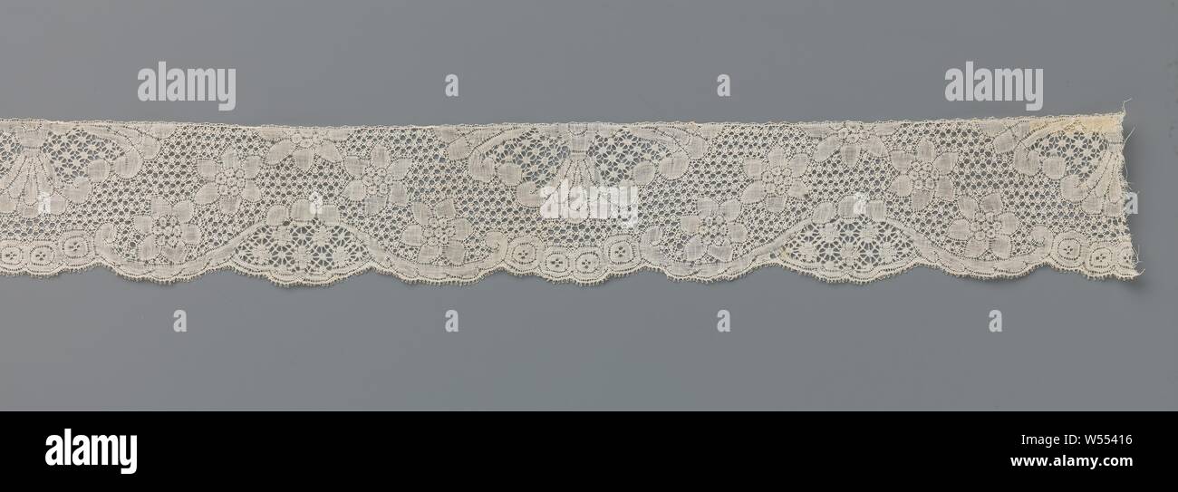 Strip of bobbin lace with a bow of six-leaf flowers and fan, Natural strip of bobbin lace, Binche lace. The pattern consists of an alternation of two symmetrical compositions. One composition consists of a bow of five flowers with six petals, with the top flower, which sits against the top edge, cut in half. Under the arch there is a pointed oval-shaped cartouche along the lower edge. The other composition consists of a fan-shaped motif hanging down from the top edge. Below the fan there are four concatenated circles along the bottom edge that look like knots. The scalloped bottom comes from Stock Photo