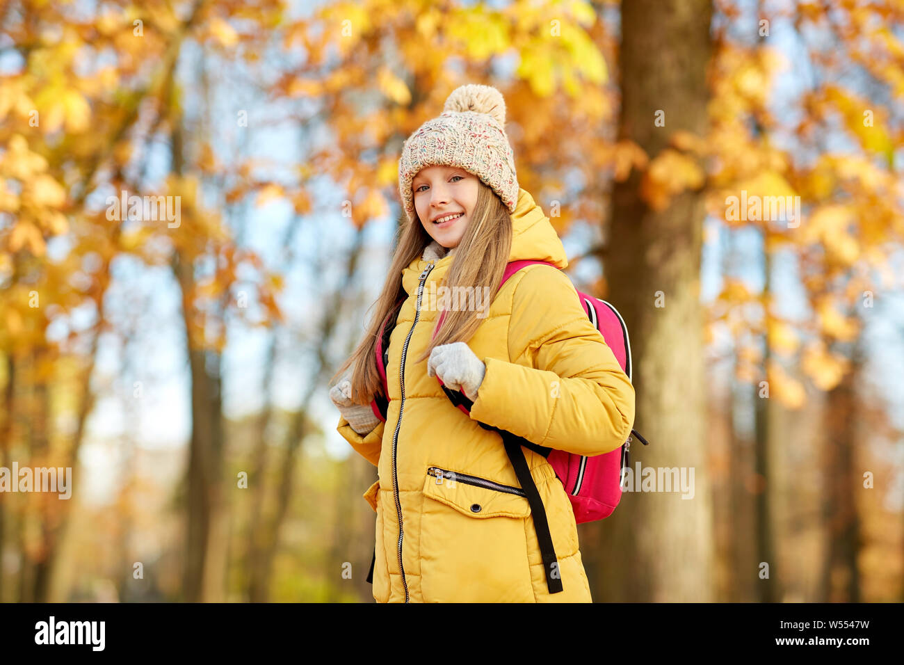 happy student girl with schoolbag at autumn park Stock Photo