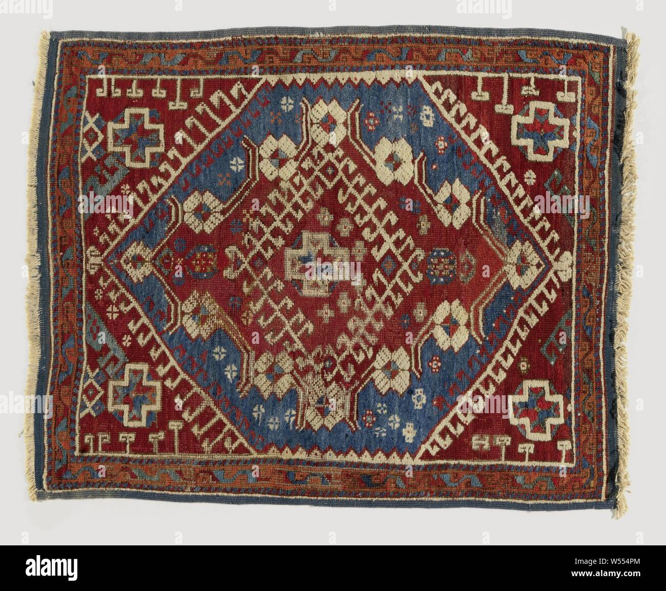 Oriental carpet, medallion rug. In the blue hexagonal center is a concentric diamond, surrounded by hooks and stems with rosette flowers. In the heart a cruciform star flower. Button: Ghiordes button., Yagcibedir (possibly), 1700 - 1900, ketting en inslag, h 117 cm × w 92 cm Stock Photo