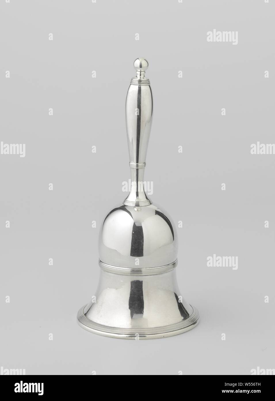 Table bell with fillet edges, The round bell-shaped bell is made up of a concave and a convex section and is articulated at the bottom and at the separation between the two sections by fillet edges. The handle-shaped handle is slightly strapped on the underside, then it widens to rejuvenate itself towards the end. It is articulated at the top and bottom and at a third of the height by fillet edges. It is crowned by a spherical button., Fa. W. Diemont en Zoon, Amsterdam, 1823, silver (metal), h 18.6 cm × d 8.7 cm × w 356 Stock Photo
