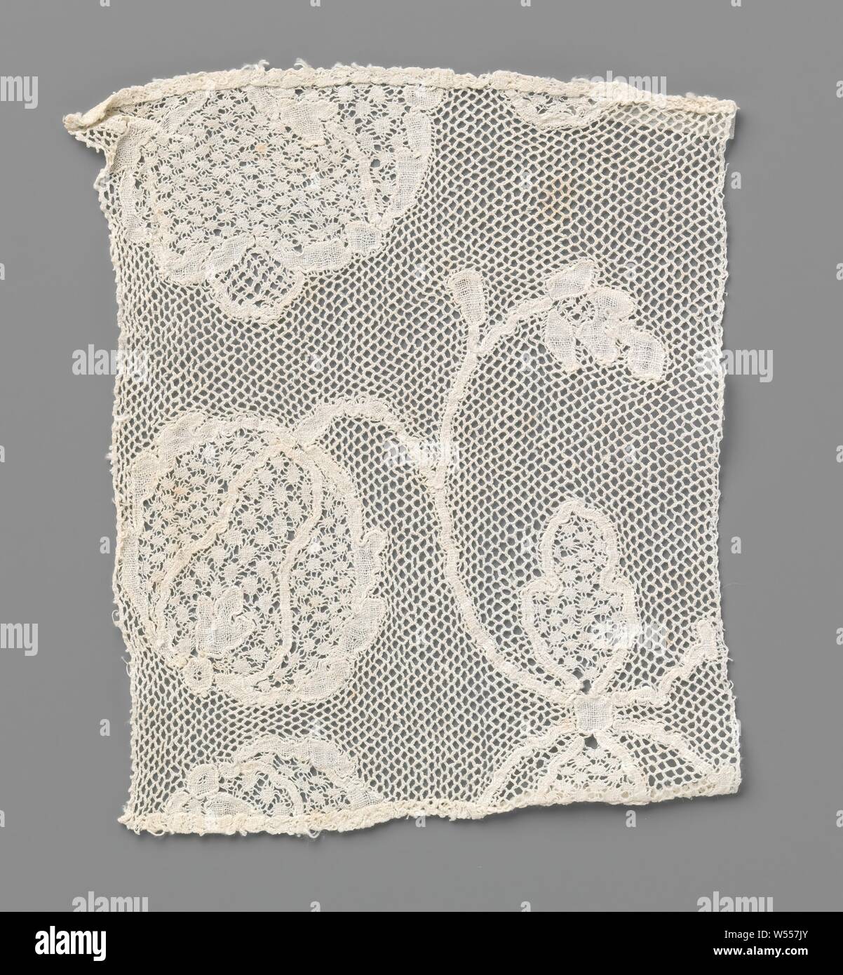 Strip of bobbin lace with a part of two facing round flowers with bow, Strip of natural-colored bobbin lace, pot lace. The pattern is incomplete, anonymous, Southern Netherlands, c. 1750 - c. 1799, linen (material), pot lace, l 14 cm × w 12 cm Stock Photo