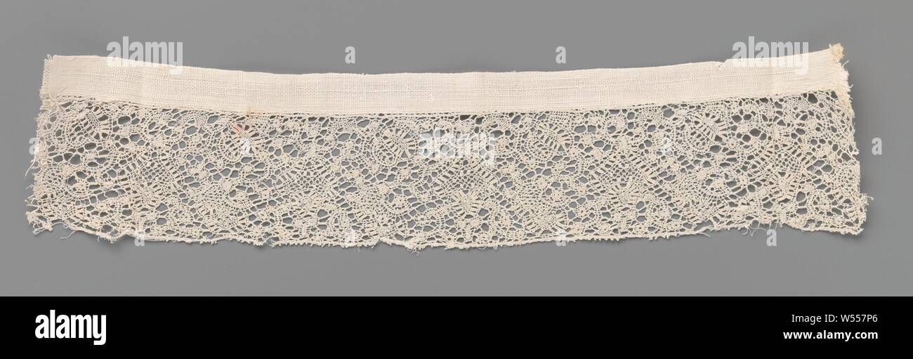 Strip of bobbin lace with slanting ovals and hearts with droplet, Strip of natural-colored bobbin lace, Binche lace. The repeating pattern consists of tangle of small motifs made with different ornamental grounds. Narrow decorative bands with rectangles, made in shape, form obliquely placed ovals along the top and on the center line, always between two ovals, an inverted heart with a drop between the curves. The motifs are connected by an irregular ornamental ground, a snow ground. The underside of the strip is finished straight and provided with picots. The top edge is finished with a linen Stock Photo