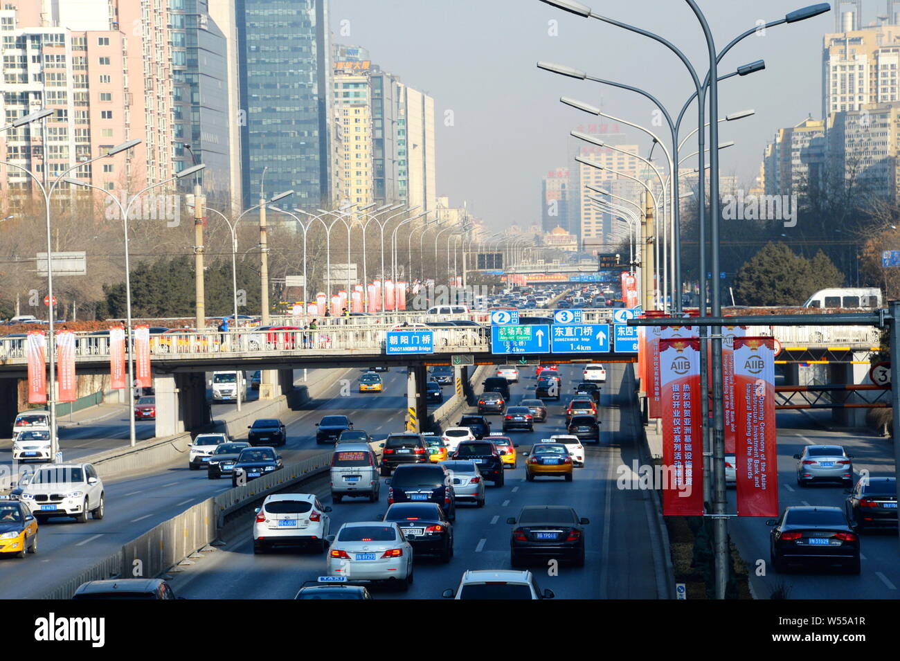 --FILE--Cars drive past banners advertising the opening ceremony of the Asian Infrastructure Investment Bank (AIIB) and inaugural meeting of the board Stock Photo