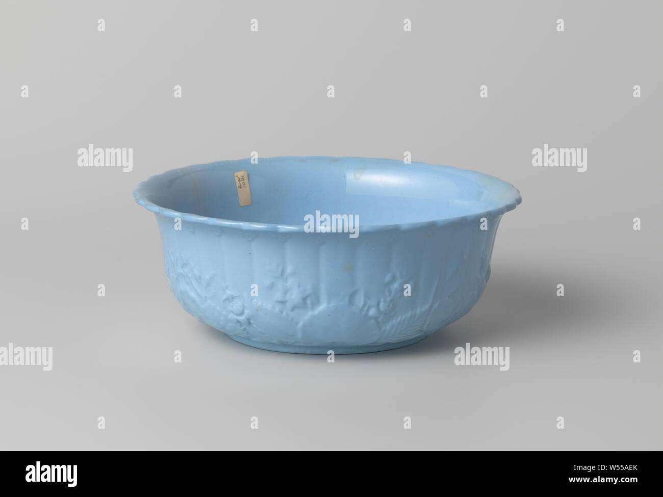 Bowl, blue, with flowers and leaves in relief, Bowl of earthenware, blue stone. The walls with flowers and leaves in relief, the inside smooth. The bowl has a scalloped top edge., Petrus Regout, Maastricht, c. 1860 - c. 1890, h 8.0 cm × d 20.7 cm Stock Photo