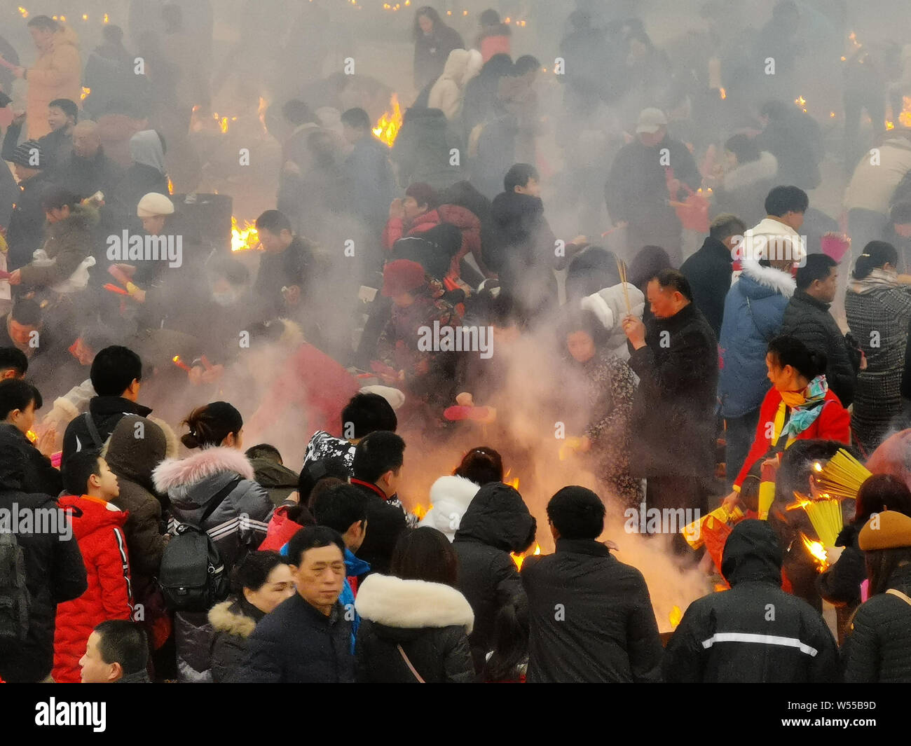 Chinese worshippers burn incense sticks to pray for wealth and ...