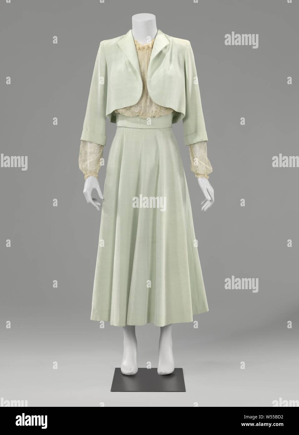 Suit with blouse or trois-pièces, Trois-pièces consisting of a light green ribbed, moire satin suit (jacket (a), skirt (b)) and a lace blouse (c). Worn by the donator at her wedding in 1948 in combination with a light green satin with lace trimmed diadem (d) and white leather pumps, mevrouw Stapelveld, Netherlands, 1948, silk, rayon Stock Photo