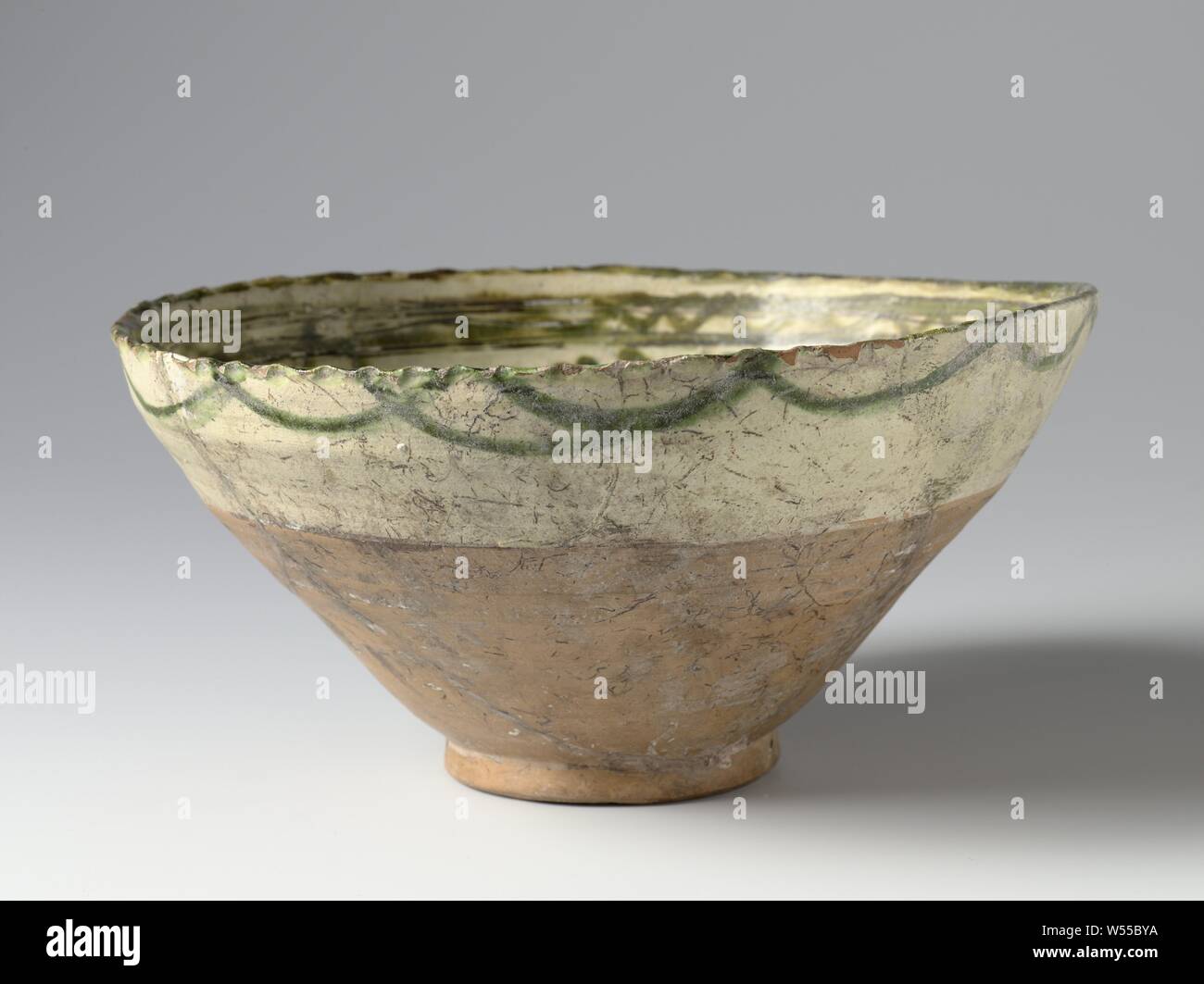 Bowl with ornamental borders, Bowl of earthenware decorated in sgraffito (incised) lines and green lead glaze with two decorative bands on the inside wall and a wavy line on the outside., anonymous, Amol, c. 1000 - c. 1199, earthenware, glaze, vitrification, h 10.6 cm d 20.8 cm d 7.3 cm Stock Photo