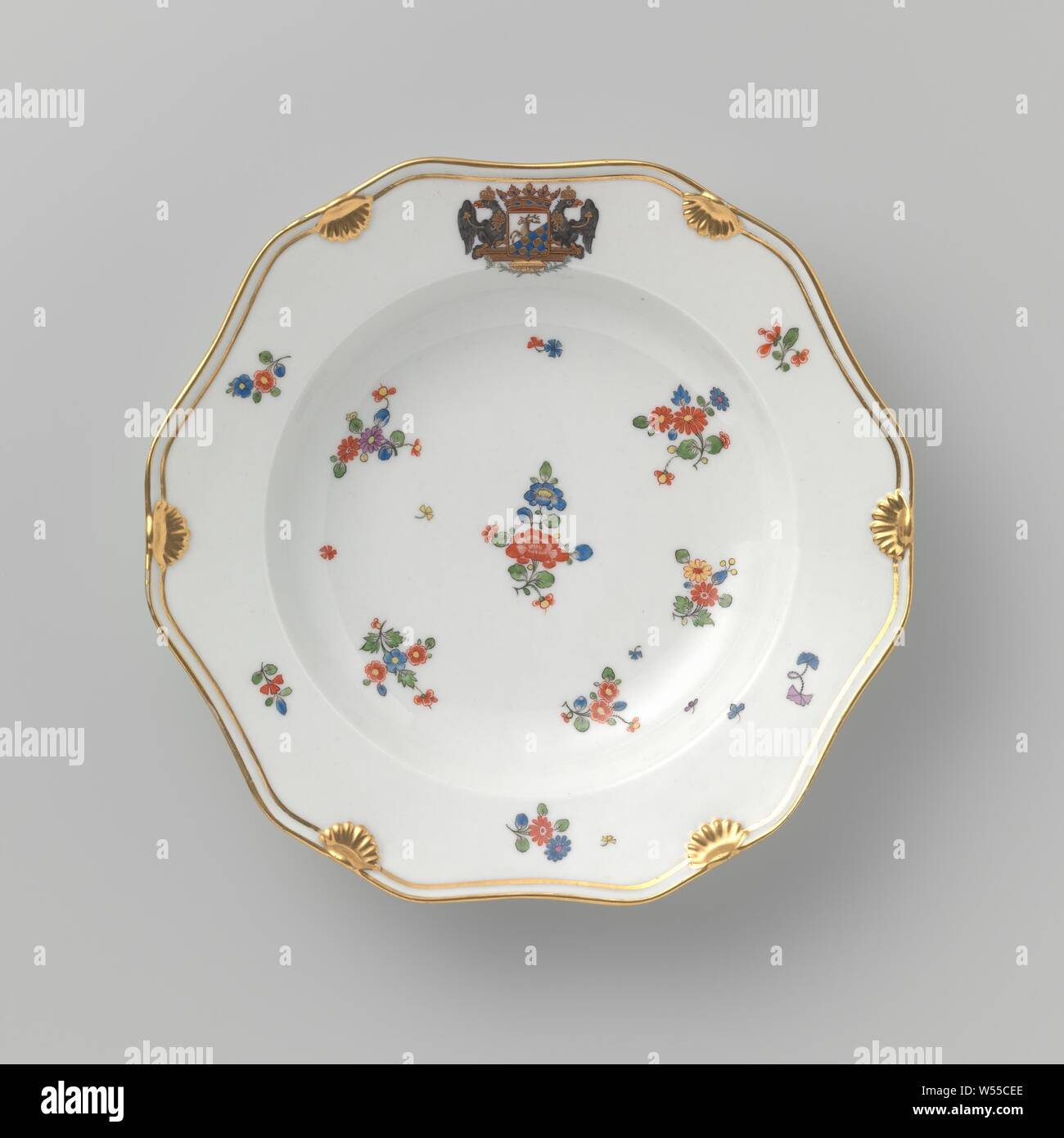 Plate with the coat of ams or Count Heinrich of Podewils and flower sprays, 12-sided porcelain plate painted on the glaze in blue, red, pink, green, yellow, black and gold. On the shelf, the wall and the border flower branches and scatter flowers in the style of the Japanese Kakiemon porcelain. The crowned weapon of Count Heinrich von Podewils (1695-1760) on the rim. Along the edge a double golden line interrupted by six shell motifs. The rear with two scatter flowers. Marked on the bottom with the scepter and number 23., Königliche Porzellan Manufaktur, Berlin, c. 1763 - c. 1800, porcelain Stock Photo