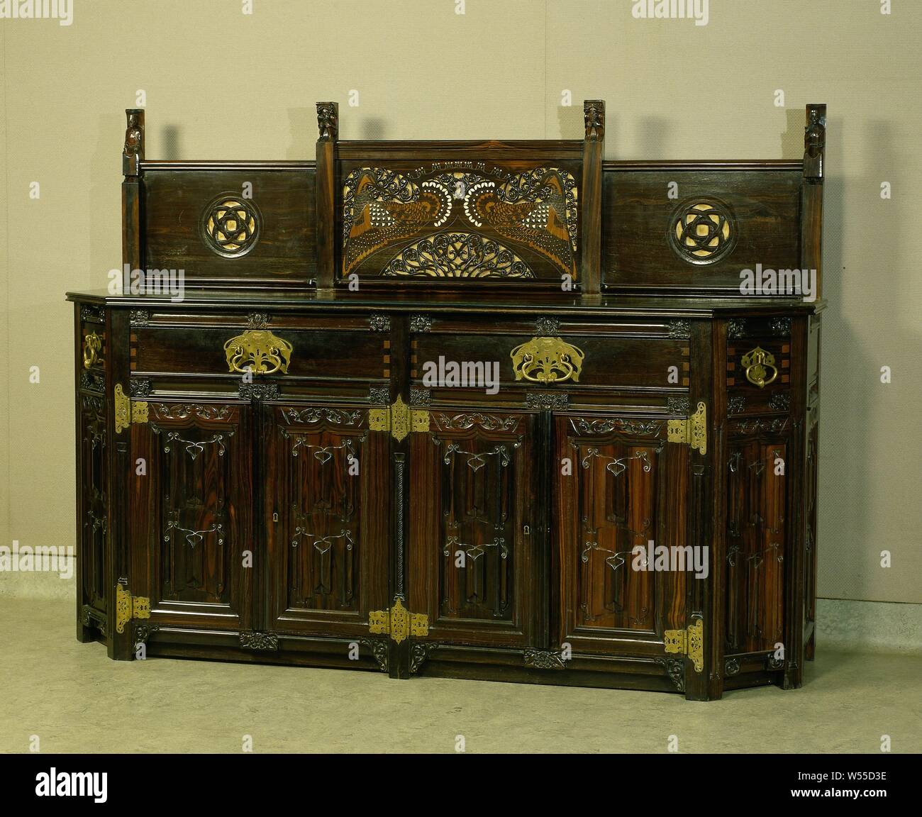 Buffet with drawers and doors decorated with letter panels and other gothic decorations. With carved monogram DVS, Buffet with upright of coromandel inlaid with walnut, ivory and brass, the blindwork of oak, with two drawers above four doors and in the corner posts two smaller drawers. Decorated with letter panels and with gothic and other decorative motifs. In the rebellion the carved monogram DVS for Mr. Th.G. Dentz van Schaick., Kunsthandel E.J. van Wisselingh, Amsterdam, c. 1910 - c. 1918, wood (plant material), padouk (wood), mahogany (wood), ivory, leather, brass (alloy), blindwerk Stock Photo