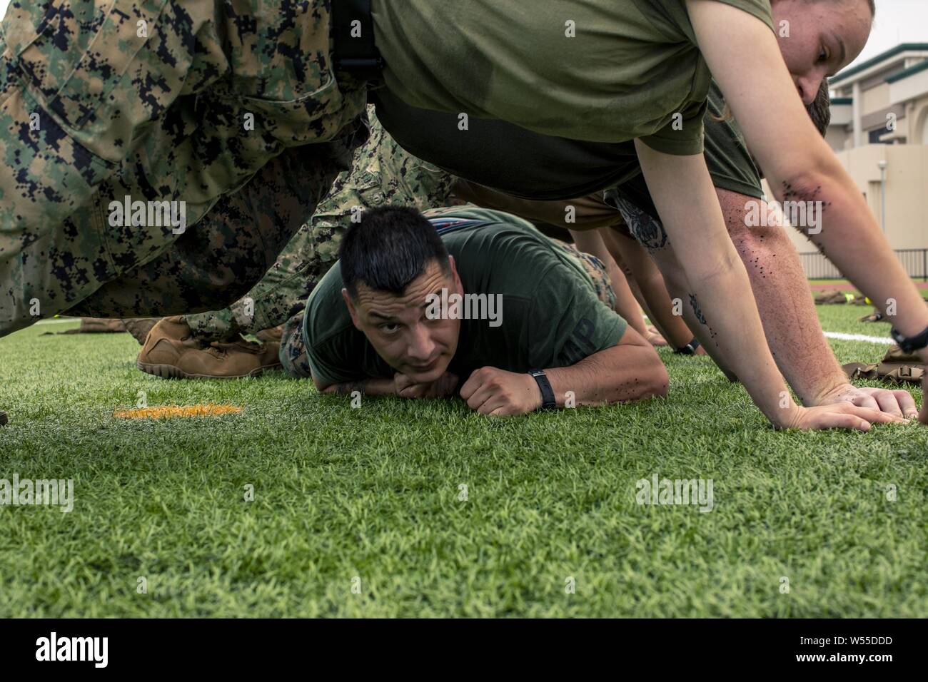 U.S. Marine GySgt, July 26, 2019. Juan Flores, with Headquarters and Headquarters Squadron, conducts low crawls during a squadron physical training event at Marine Corps Air Station Iwakuni, Japan, July 26, 2019. HandHS supports tenant commands at MCAS Iwakuni through air traffic control, aircraft rescue and firefighting and fuels along with many other capabilities. Regular unit physical training events like this help maintain readiness, morale and unit cohesion. (U.S. Marine Corps photo by Lance Cpl. Lauren Brune). () Stock Photo