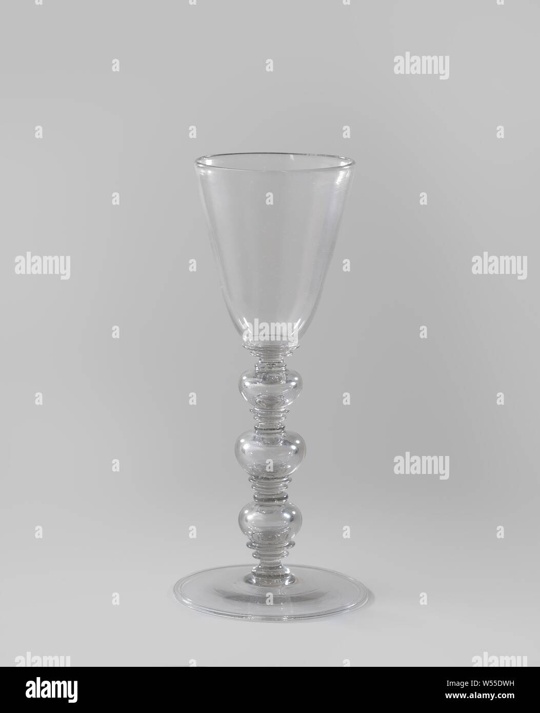 Cup with three hollow balusters, Cup of clear gray tinted glass. Flat base with folded edge. Stem made up of three hollow nodes between four times three discs. Funnel-shaped chalice rounded at the bottom., anonymous, Netherlands, c. 1650 - c. 1700, glass, glassblowing, h 28.3 cm × d 12.5 cm Stock Photo