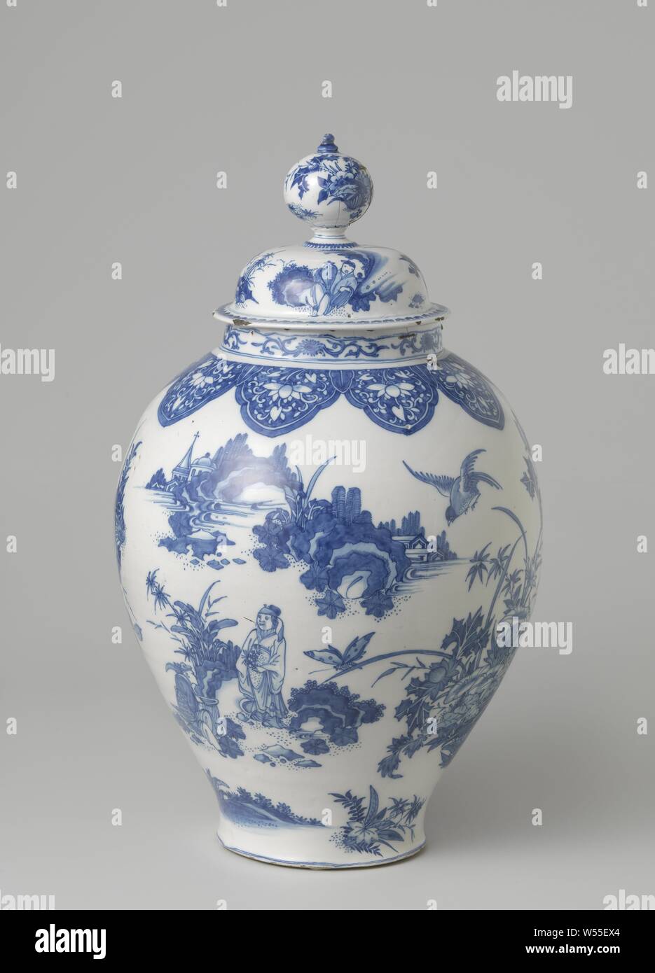 Lidded jar Pot with lid, painted in blue with bouquets, Chinese figures and a flying phoenix, Pot with lid, painted in blue on white ground with groups of Chinese, a flying phoenix and large flower bouquets, all of which are separate, unrelated and not done by cartouches when decorative elements are scattered over the convex surface. Everything in Chinese style derived from decorations on Chinese porcelain, but pieces from it and their own interpretation or processing: Chinoiserie, bunch of flowers, ornament, fabulous animals, birds: phoenix, anonymous, Delft, c. 1660 - c. 1670, h 47 cm d 37 Stock Photo