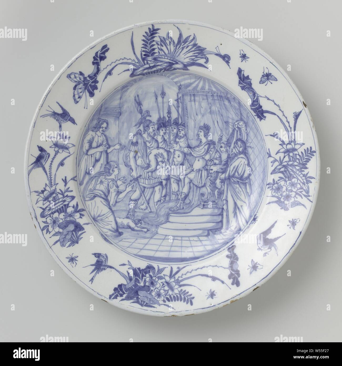 Saucer, painted with the judgment of King Solomon, Saucer of faience, painted blue in the glaze. On the shelf a representation of the Judgment of King Solomon. On the border flowers, butterflies and birds after a Chinese example, the judgment of Solomon (1 Kings 3: 16-28), Willem Jansz. Verstraeten (attributed to workshop of), Haarlem, c. 1655 - c. 1660, h 6.5 cm × d 38.7 cm Stock Photo