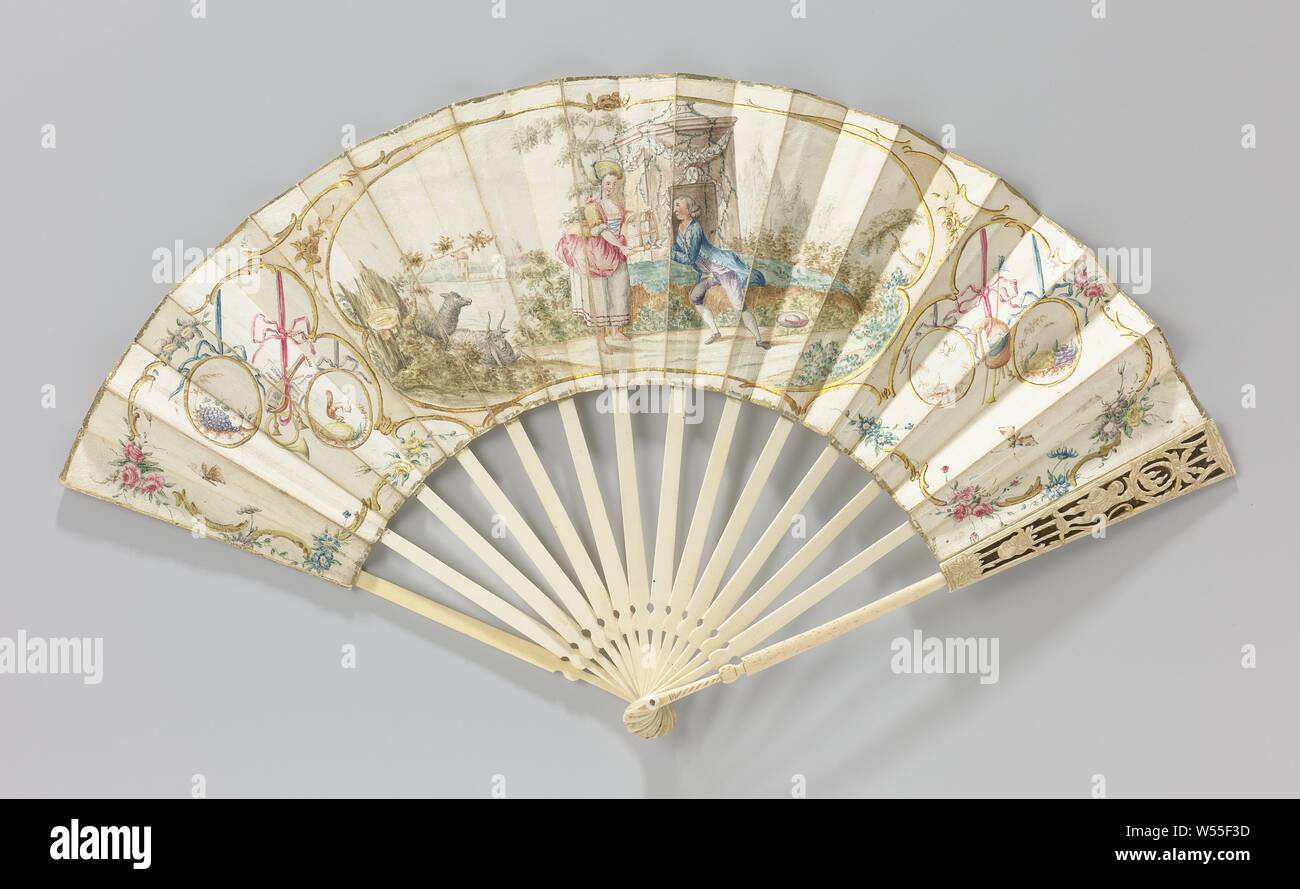 Folding fan with a pastoral scene, flanked by oval medallions and musical instruments on ribbon ribbons, Folding fan with sheet of paper with a watercolor and gold paint pastoral scene is depicted, flanked by oval medallions and musical instruments and a bow tie, on an open frame of bone. In the large central cartouche, a seated man gives a bird to a standing woman with an open bird cage. The pair is placed in front of a pedestal or small structure adorned with stone garlands and green leaf garlands. This shows the foot of a vase or sphere. To the right of the couple a forestage, to the left a Stock Photo