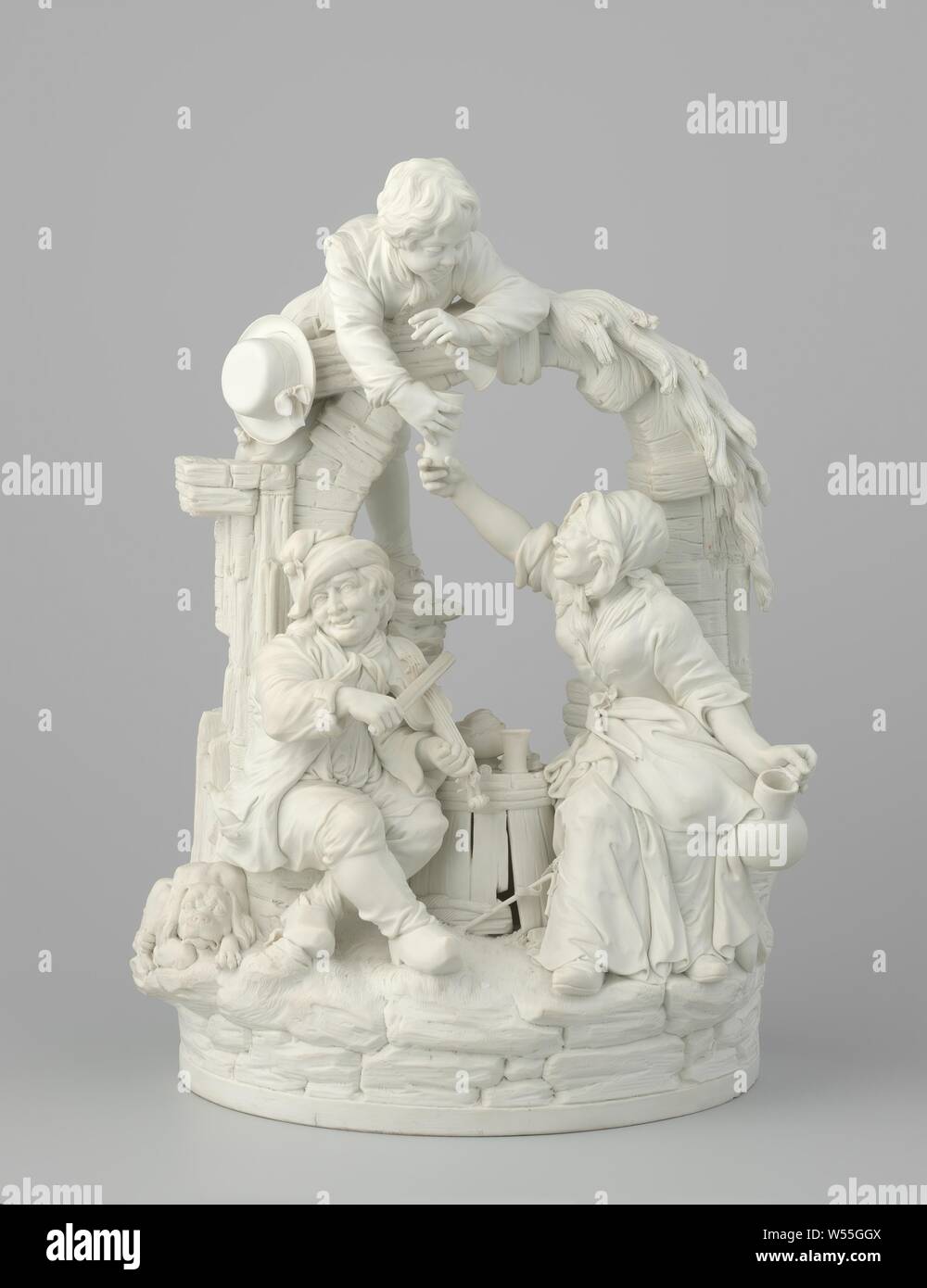 Musical Company, Figure group of biscuit porcelain representing a woman, two men and a dog under an arch. The older man and the woman sit under a decaying arc around a barrel. The man plays the violin, while the woman hands a younger man, who is hanging over the bow, a cup that she has just filled with a jug. The young man has a flute with him, next to him is a hat. The barrel between the older man and the woman is filled with a cup, a hat, a tobacco jar, two pipes and a piece of bread. The bottom of the group is made up of a stone wall with vegetation over it. Flowery vegetation also over Stock Photo