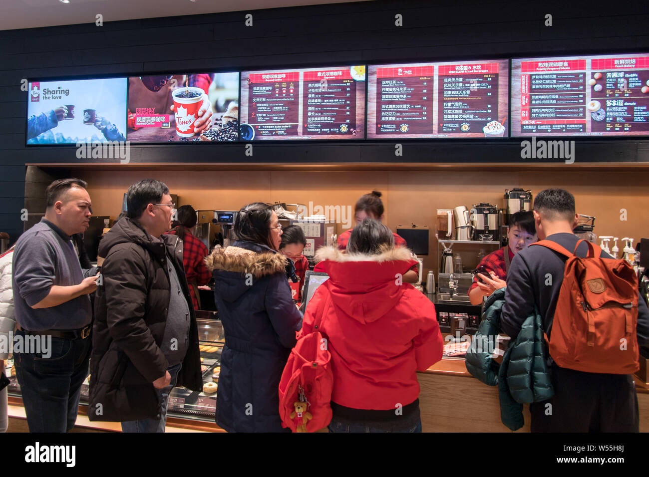 Consumers wait in line to buy coffee from Tim Hortons' first store in the Chinese mainland in Shanghai, China, 27 February 2019.   Chinese customers a Stock Photo